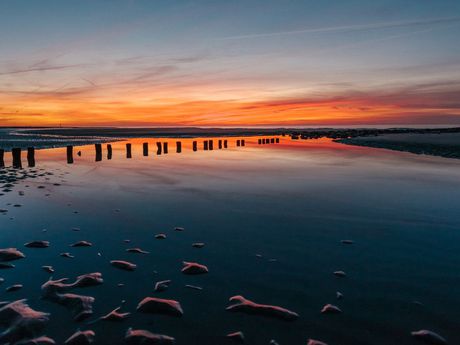 Orangener Himmel nach Sonnenuntergang über dem Wattenmeer von Norderney